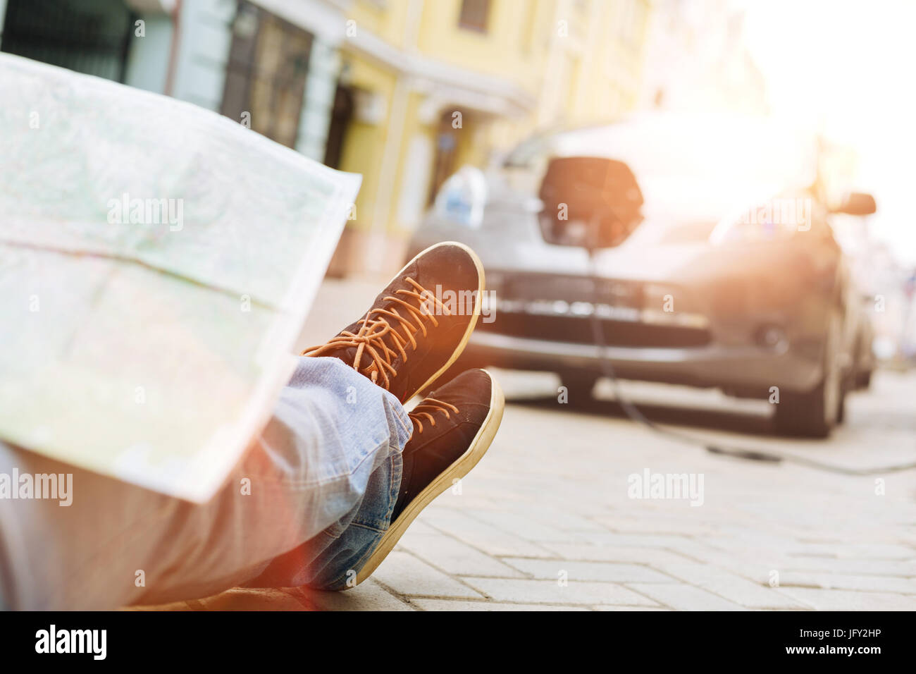 Male legs with map on them facing the car Stock Photo