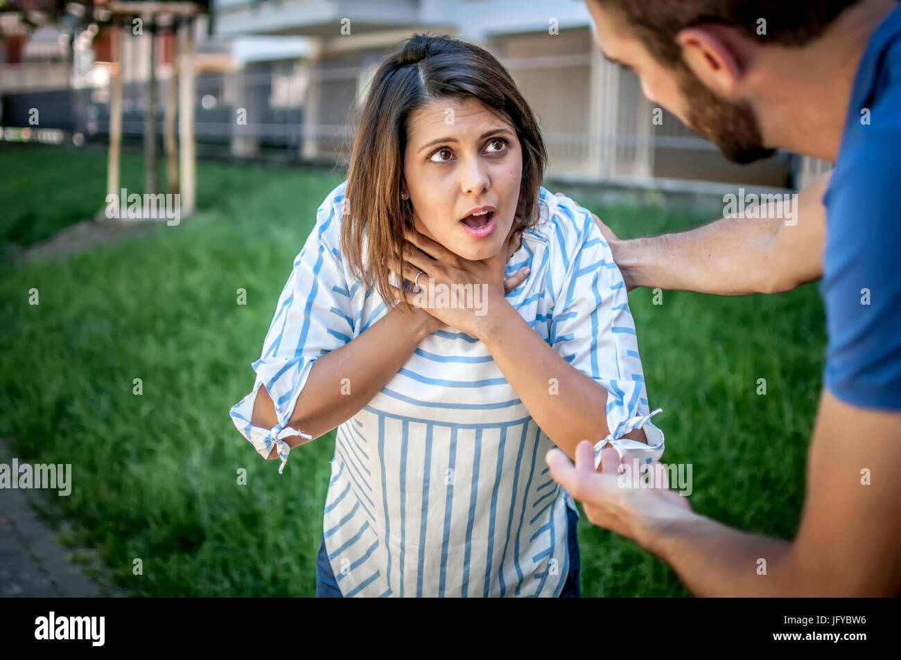 guy trying to help a girl while she's choking Stock Photo Alamy