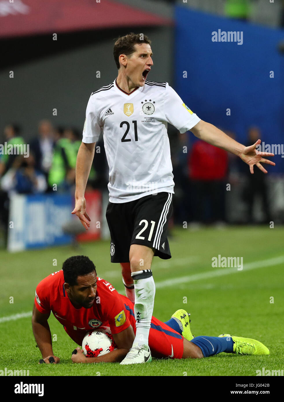 Saint Petersburg, Russia. 2nd July, 2017. Germany's Sebastian Rudy stands next to Chile's Jean Beausejour lying on the ground during the Confederations Cup finale between Chile and Germany at the Saint Petersburg Stadium in Saint Petersburg, Russia, 2 July 2017. Photo: Christian Charisius/dpa/Alamy Live News Stock Photo