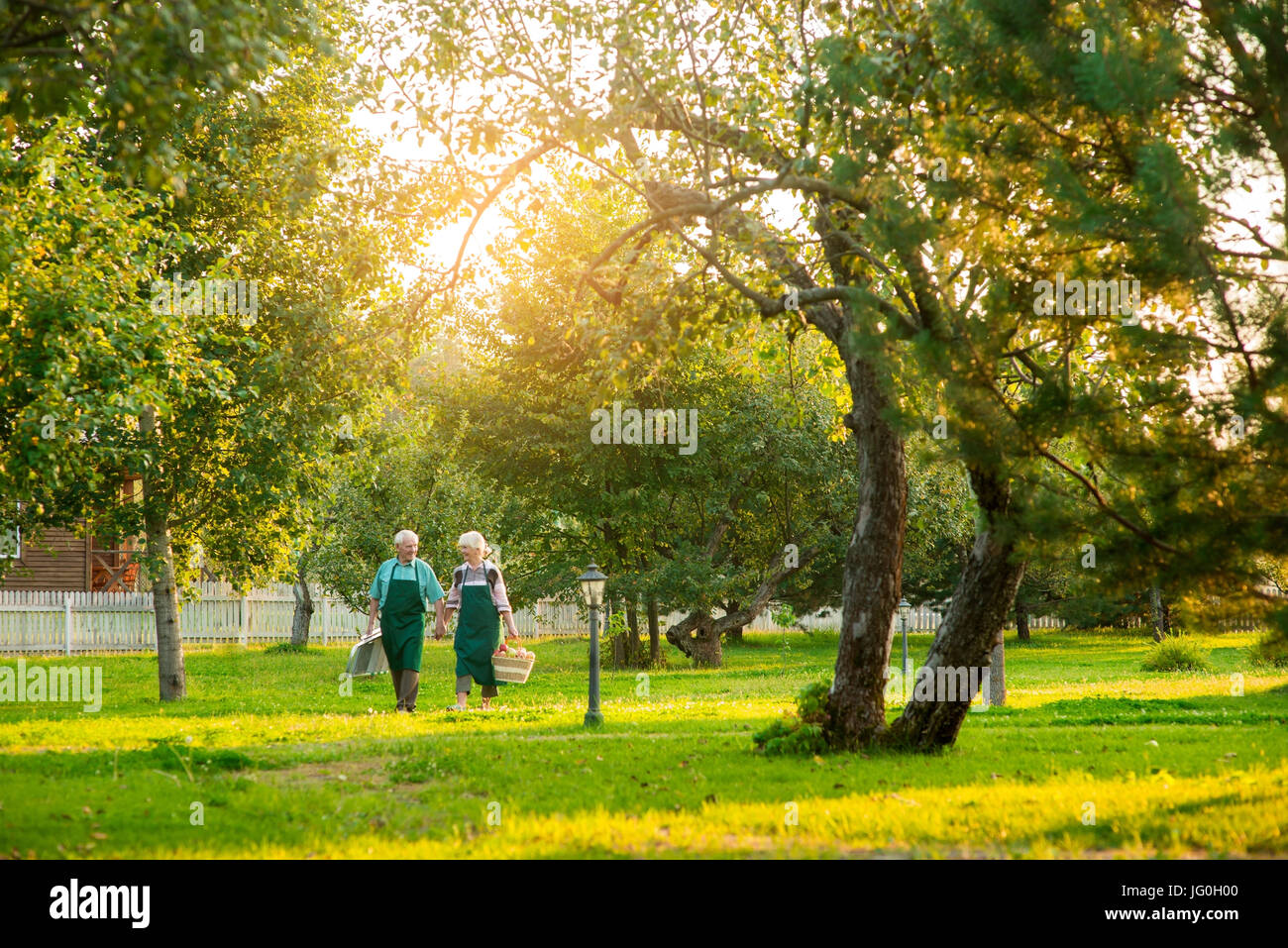 Couple of senior gardeners walking. Stock Photo