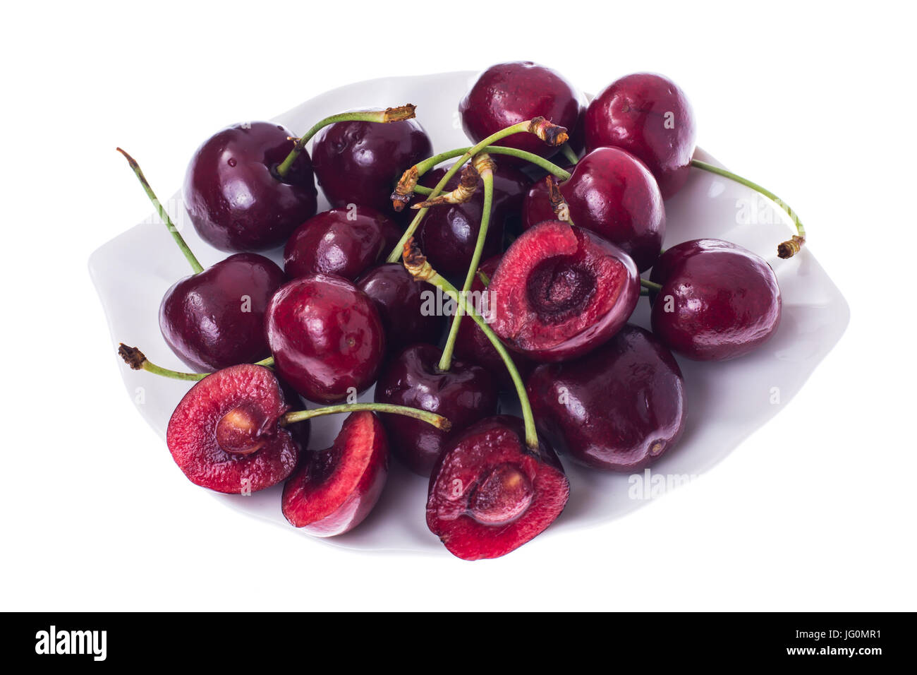 Whole and halves of ripe cherries on white plate. Studio Photo Stock ...