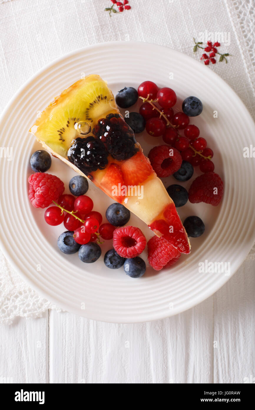 Delicious Slice of fruit berry cake close-up on a plate. vertical top view blue Stock Photo