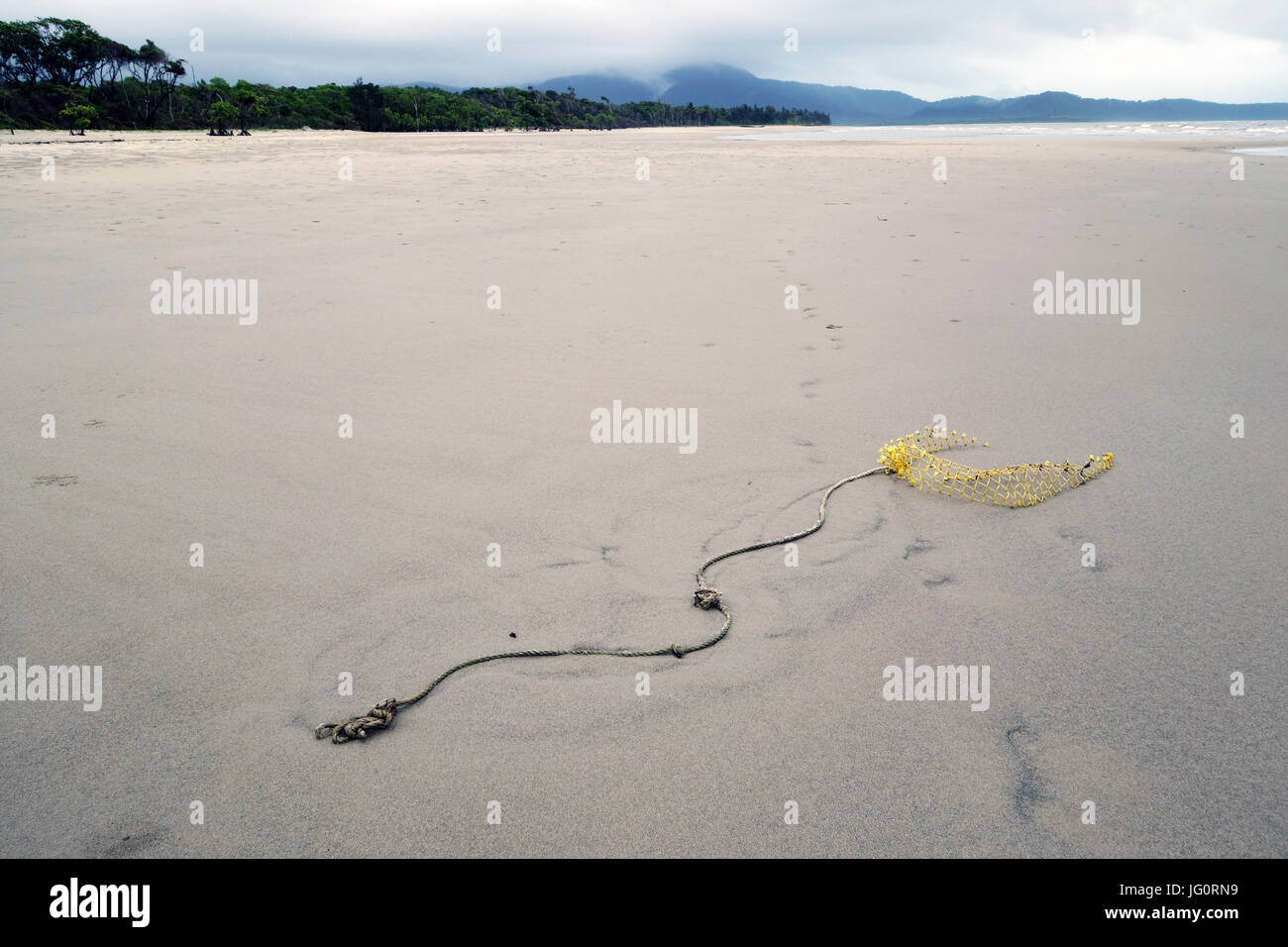 Ghost net buried in sand at the mouth of the Daintree River, on the shores of the Great Barrier Reef, far north Queensland, Australia Stock Photo