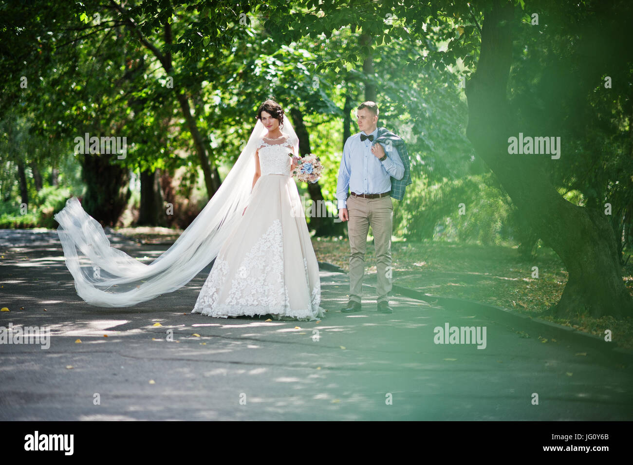Attractive young wedding couple walking and posing in the park on a ...