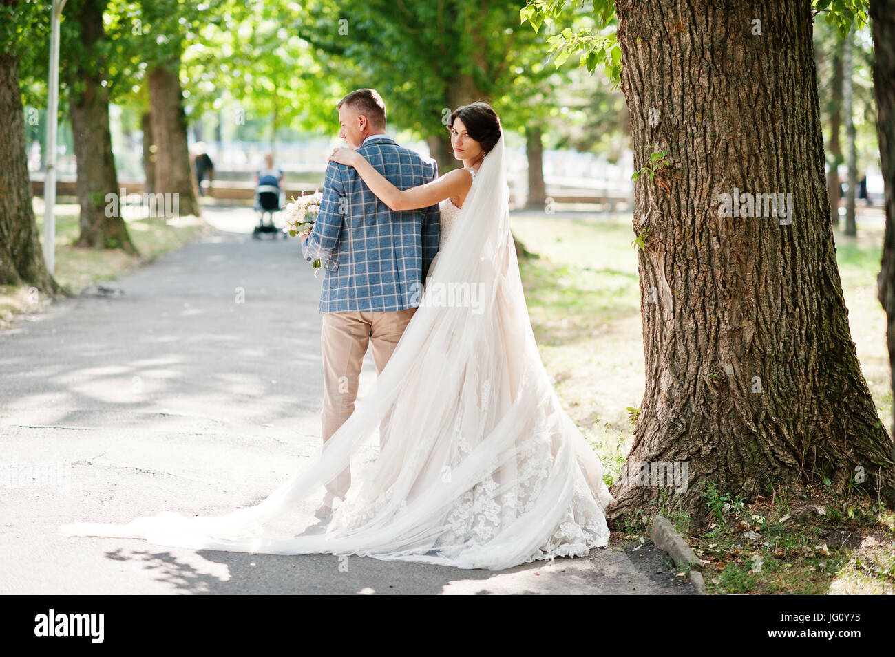 Attractive young wedding couple walking and posing in the park on a ...