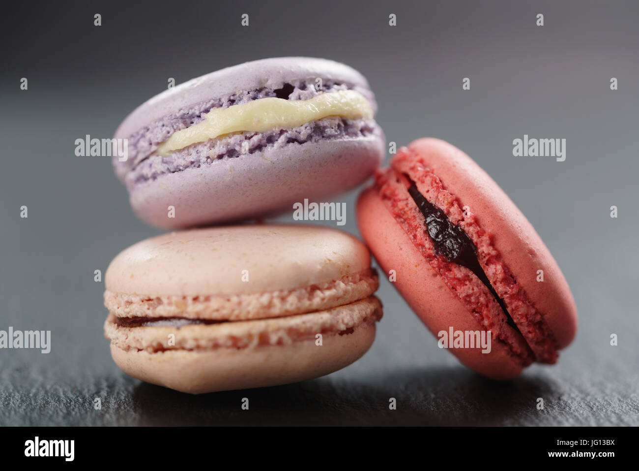 three mixed macarons on slate board, closeup Stock Photo - Alamy
