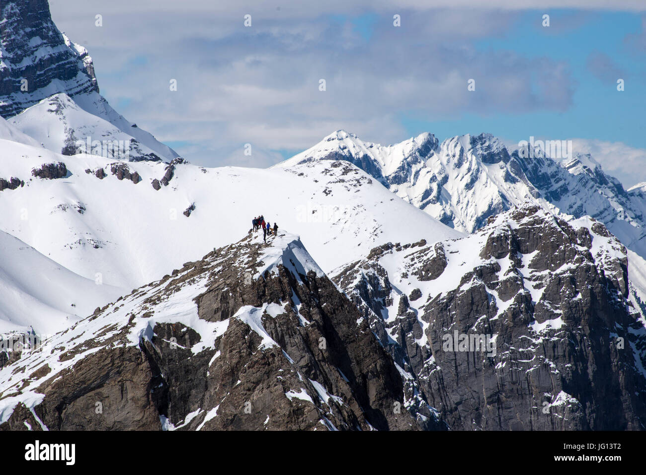 Group of hikers on top of snowy mountain peak in Canadian Rockies Stock ...