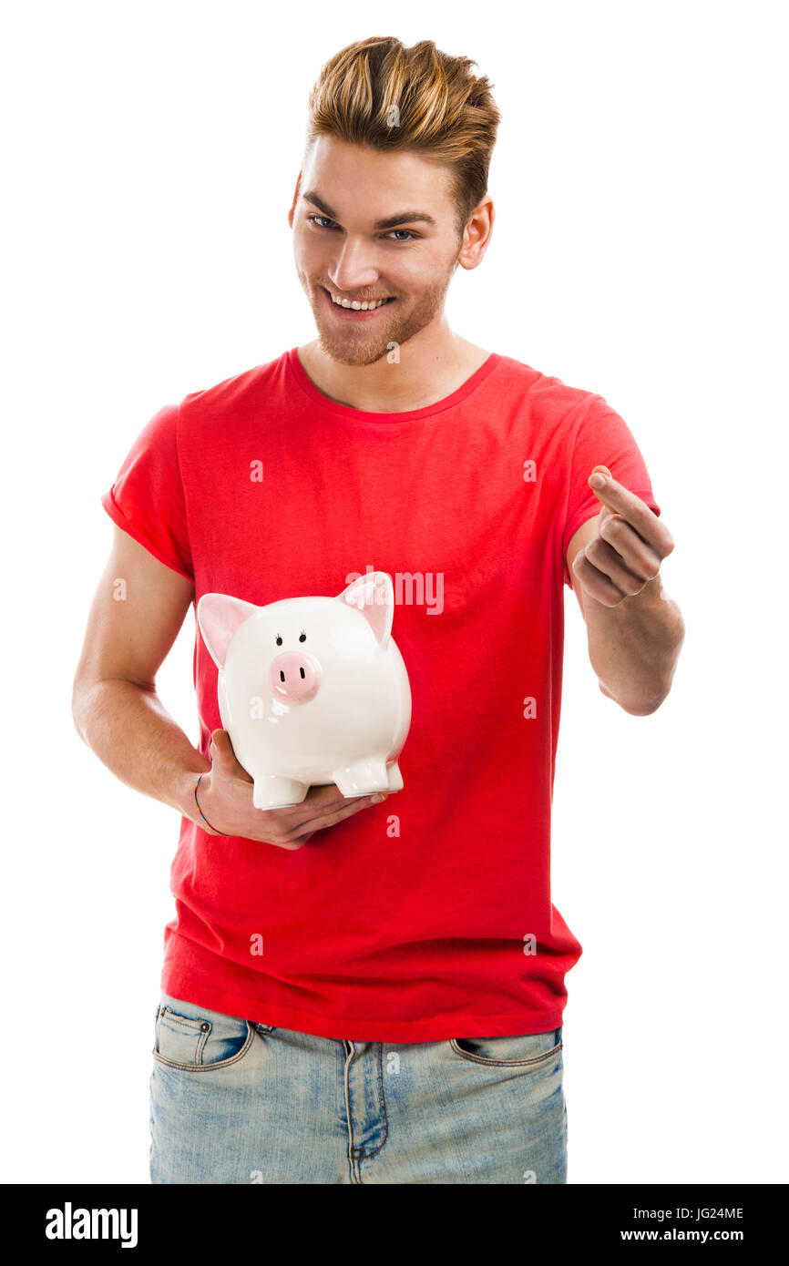 Handsome young holding a piggybank and smiling, isolated over a white ...