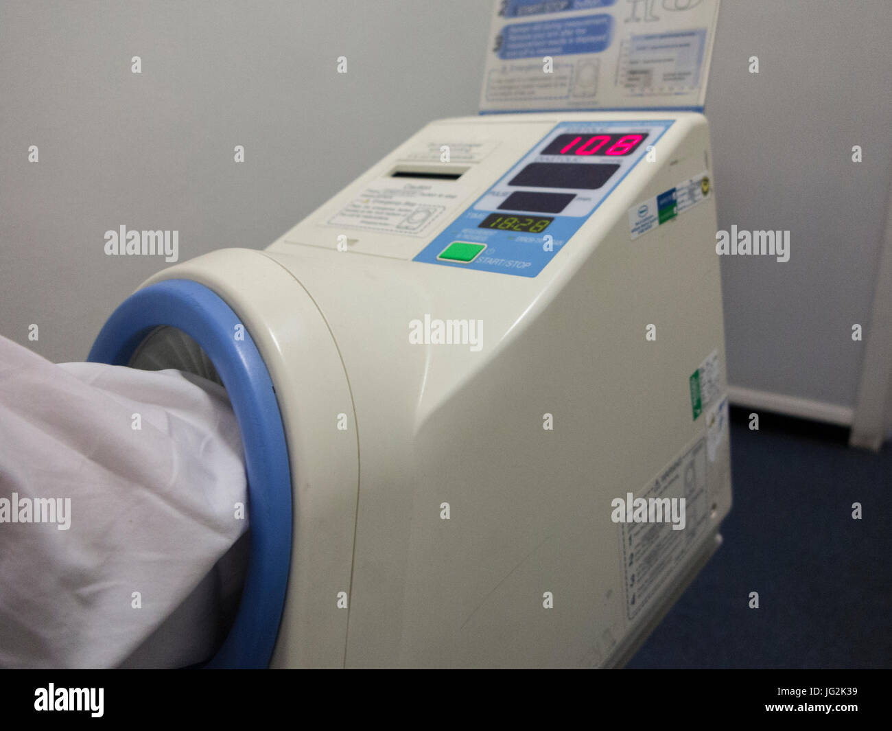 Arm in a blood pressure machine at a GP surgery Stock Photo