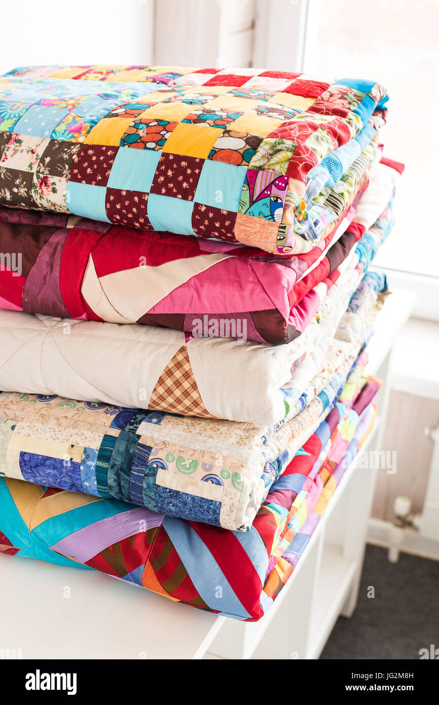 patchwork and fashion concept beautiful stack of colorful quilts