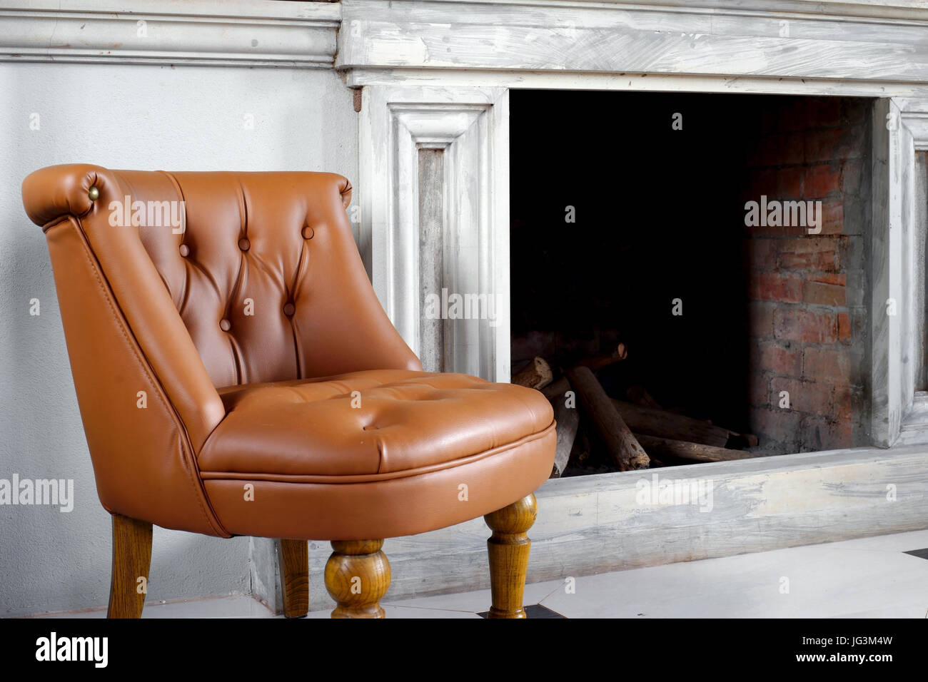 brown leather armchair in front of fireplace Stock Photo Alamy