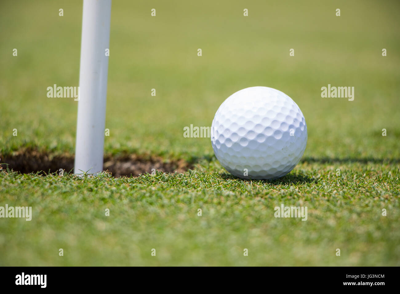 Golf Ball Near Hole Stock Photo Alamy