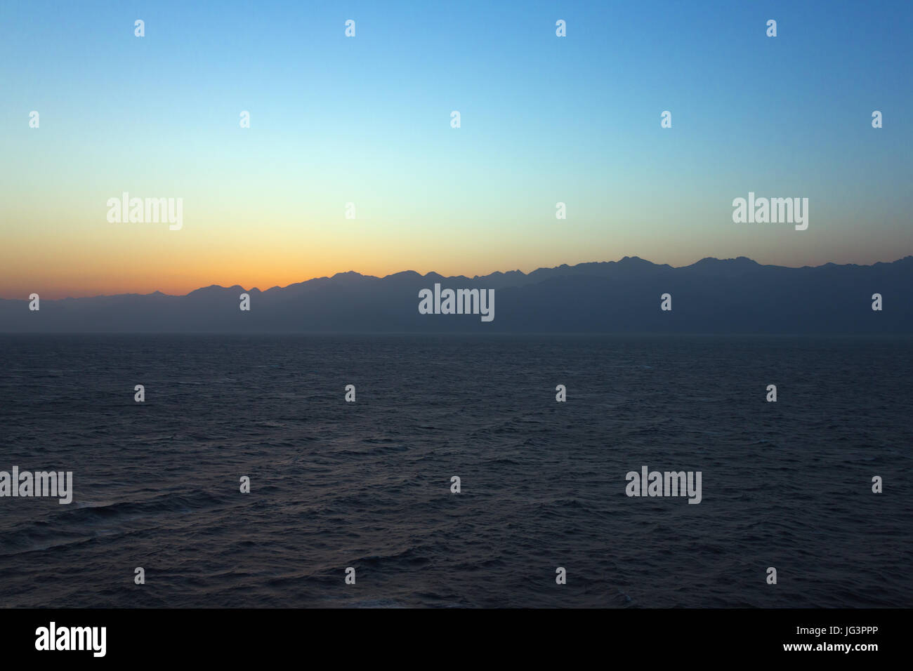 Sunrise over the Gulf of Aqaba with the sun still behind the mountains Stock Photo