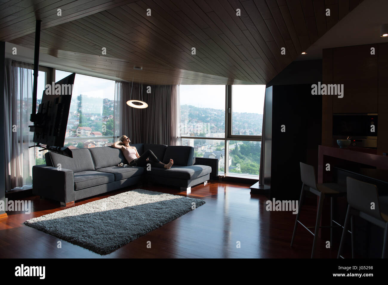 Blonde Woman Sitting On A Sofa Using Her Tablet Stock Photo - Alamy