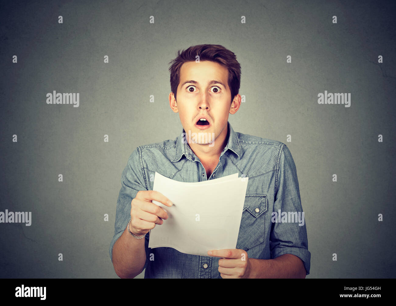Shocked man holding some documents, isolated on gray background Stock ...