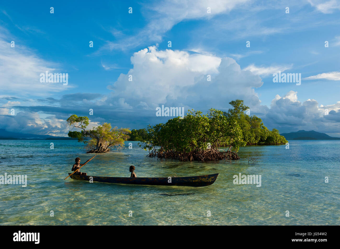 Young boys fishing in the Marovo Lagoon before dramatic clouds, Salomon Islands, Pacific Stock Photo
