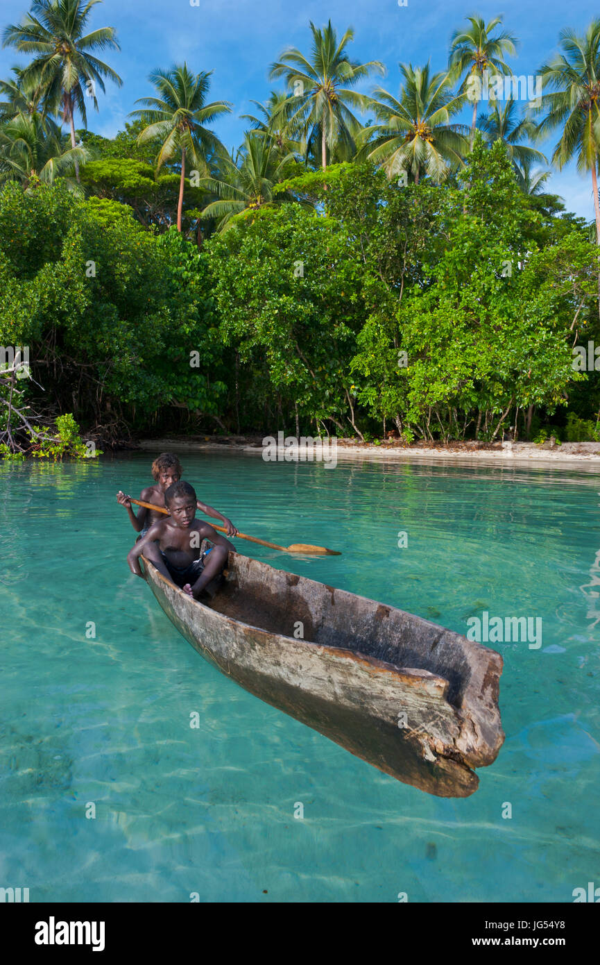 Young boys sitting in a canoe, Marovo Lagoon, Salomon Islands, Pacific Stock Photo