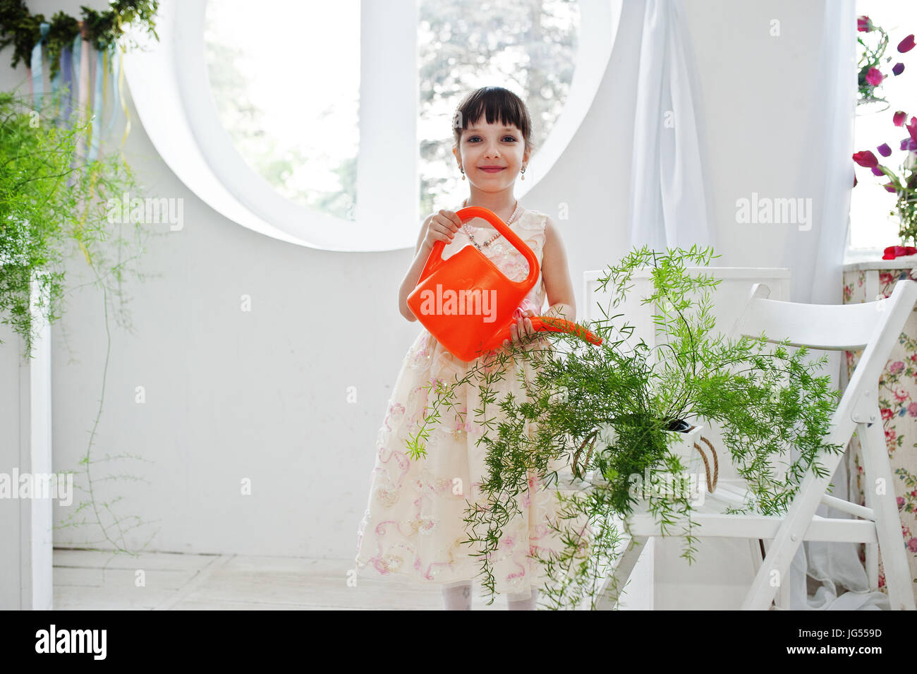 Girl watering plants in window hi-res stock photography and images - Alamy