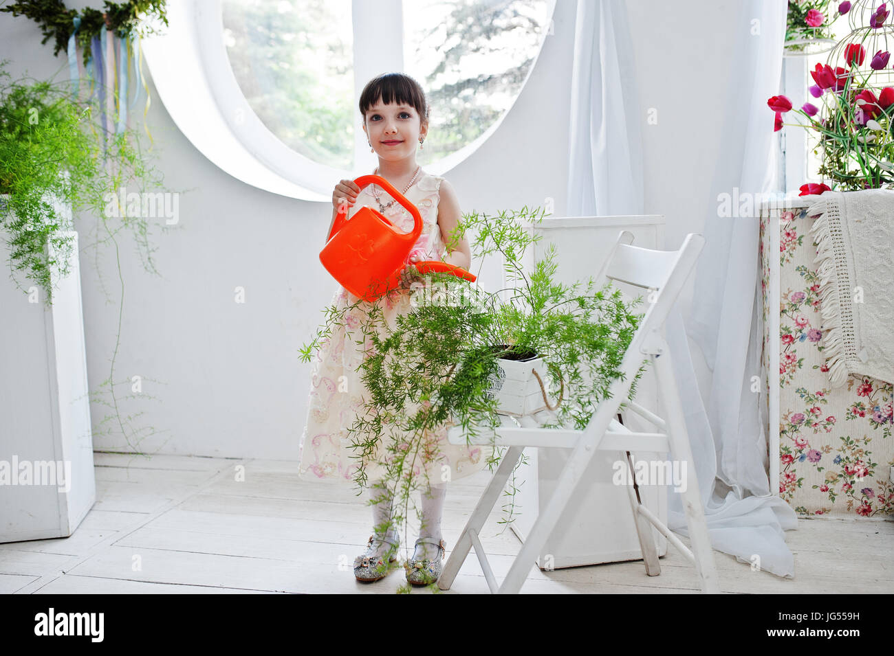 Girl watering plants in window hi-res stock photography and images - Alamy