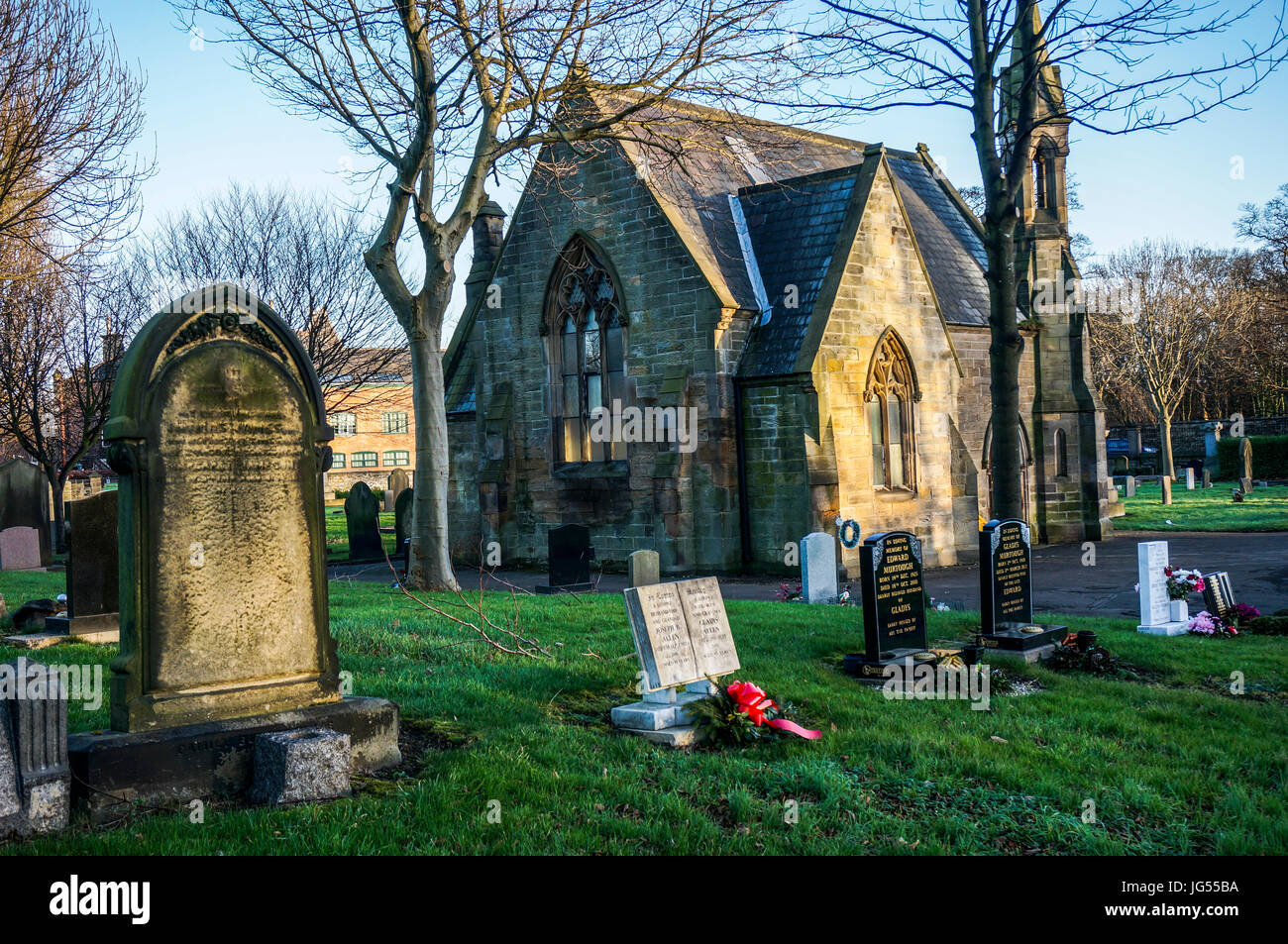 A historic old stone chapel situated in a cemetery among gravestones