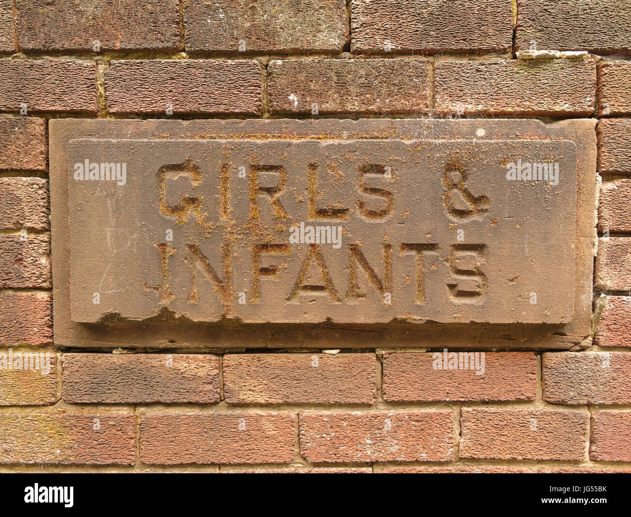 stone school building vintage sculpted sign girls and infants Stock Photo