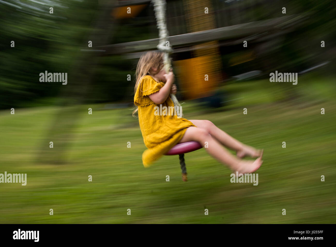 Little girl in yellow dress jumping on the trampoline Stock Photo Alamy