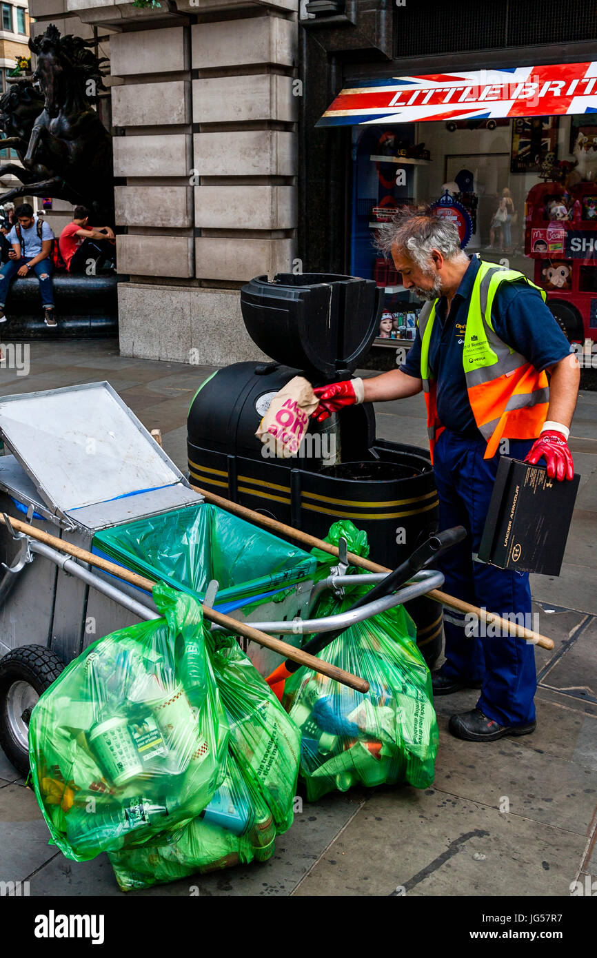 A Council Worker Collects Rubbish From A Bin, Piccadilly Circus, London, UK Stock Photo