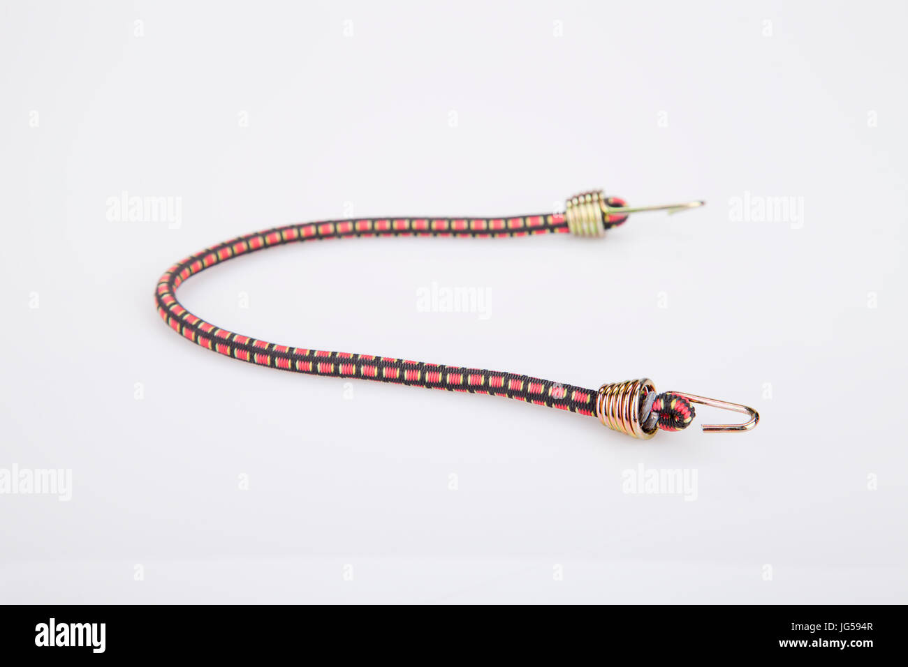 Braided elastic strap with hooks on a white surface. Bungee cord with