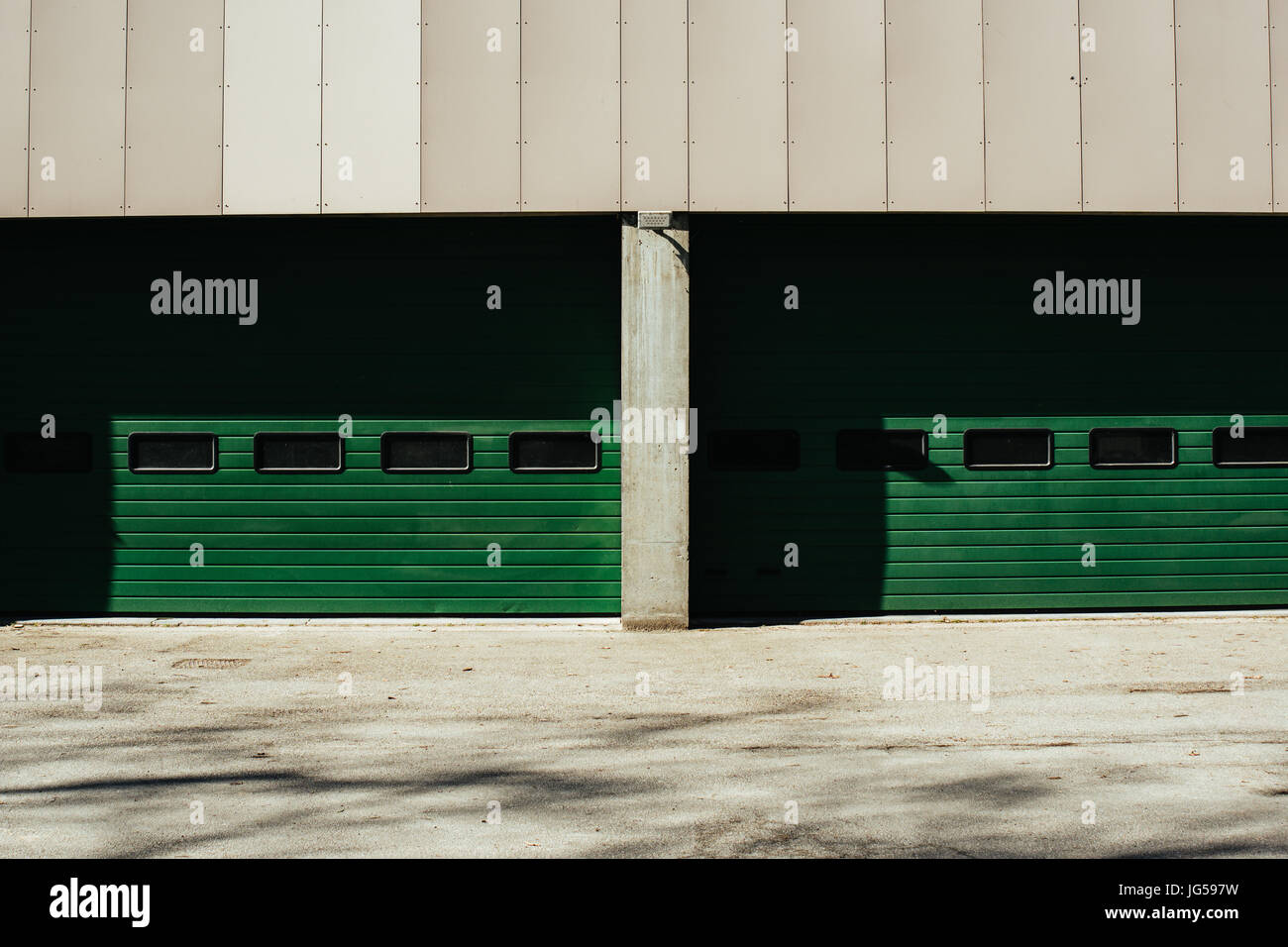 Two large green garage doors in an industrial setting. Stock Photo