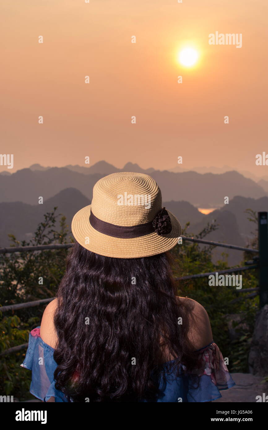 Girl enjoying sunset view from Cannon fort viewpoint in Cat ba, Vietnam Stock Photo