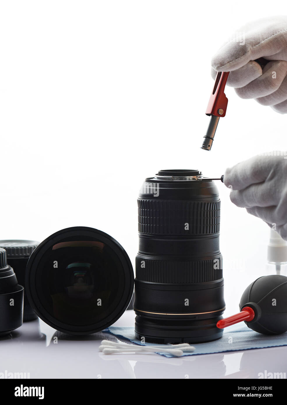 Close-up of modern repairing service white desk. Worker checking optic in photo lens Stock Photo