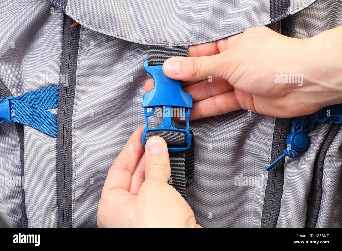 Hands zip up clasp on backpack from above. Tourist packing backpack close-up. Good travel background. Tourist concept from above. Stock Photo