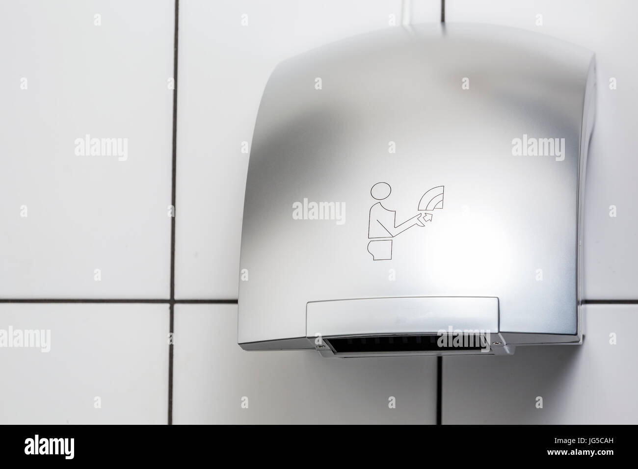 Hand dryer on white tiled wall in restroom Stock Photo Alamy