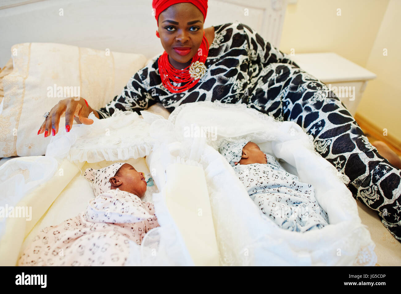Black African American Woman Dressed In Traditional Ethnic Clothes Laying Next To Her Small Babies On The Bed Stock Photo Alamy