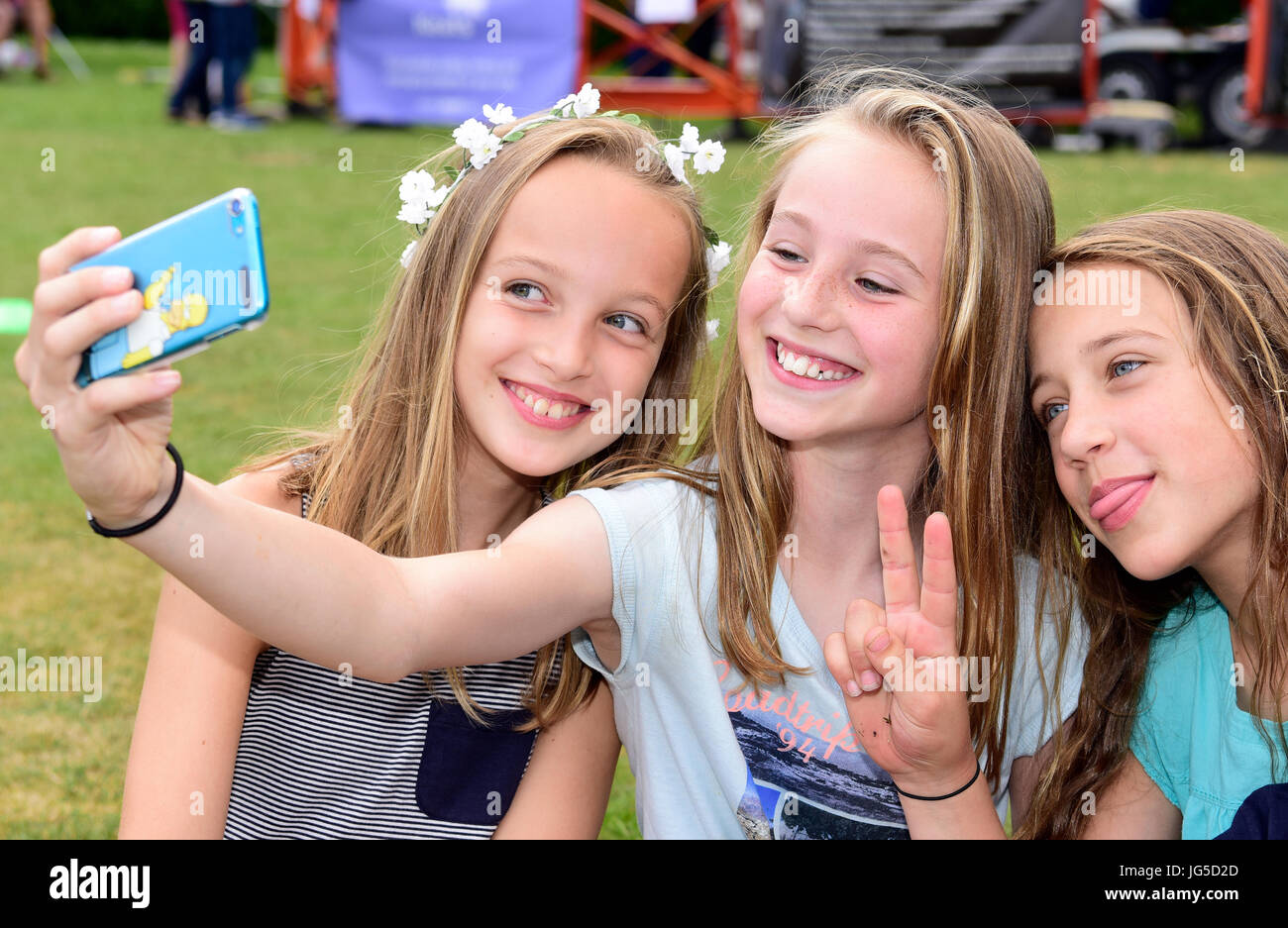 three-10-and-11-year-old-girls-taking-a-selfie-at-a-summer-fete