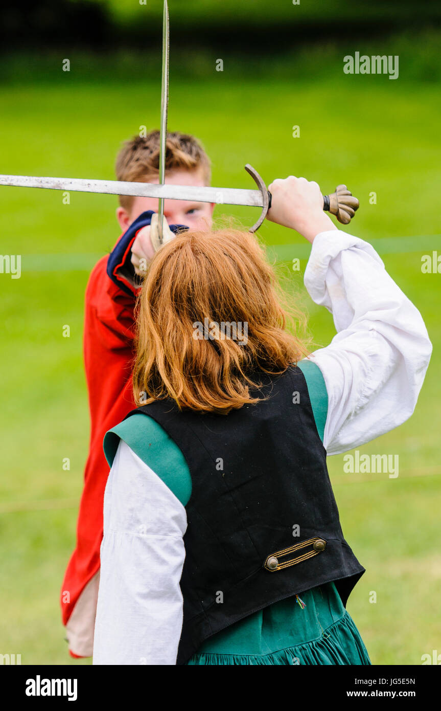 A young boy and girl practice their swordfighting technique. Stock Photo