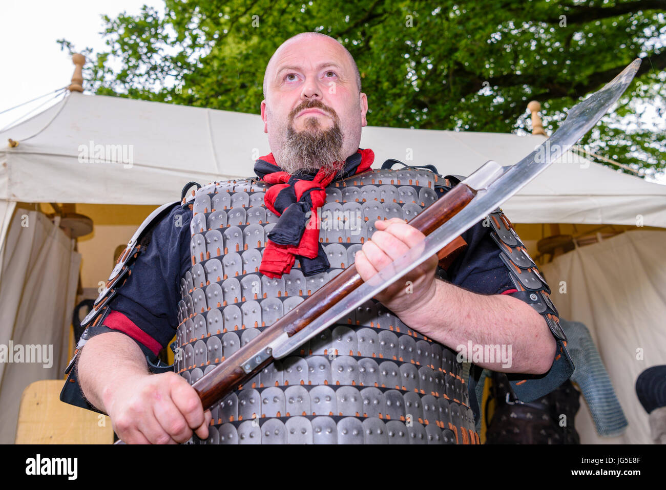 A large man holds a large, dangerous medieval sharp bladed axe Stock Photo Alamy