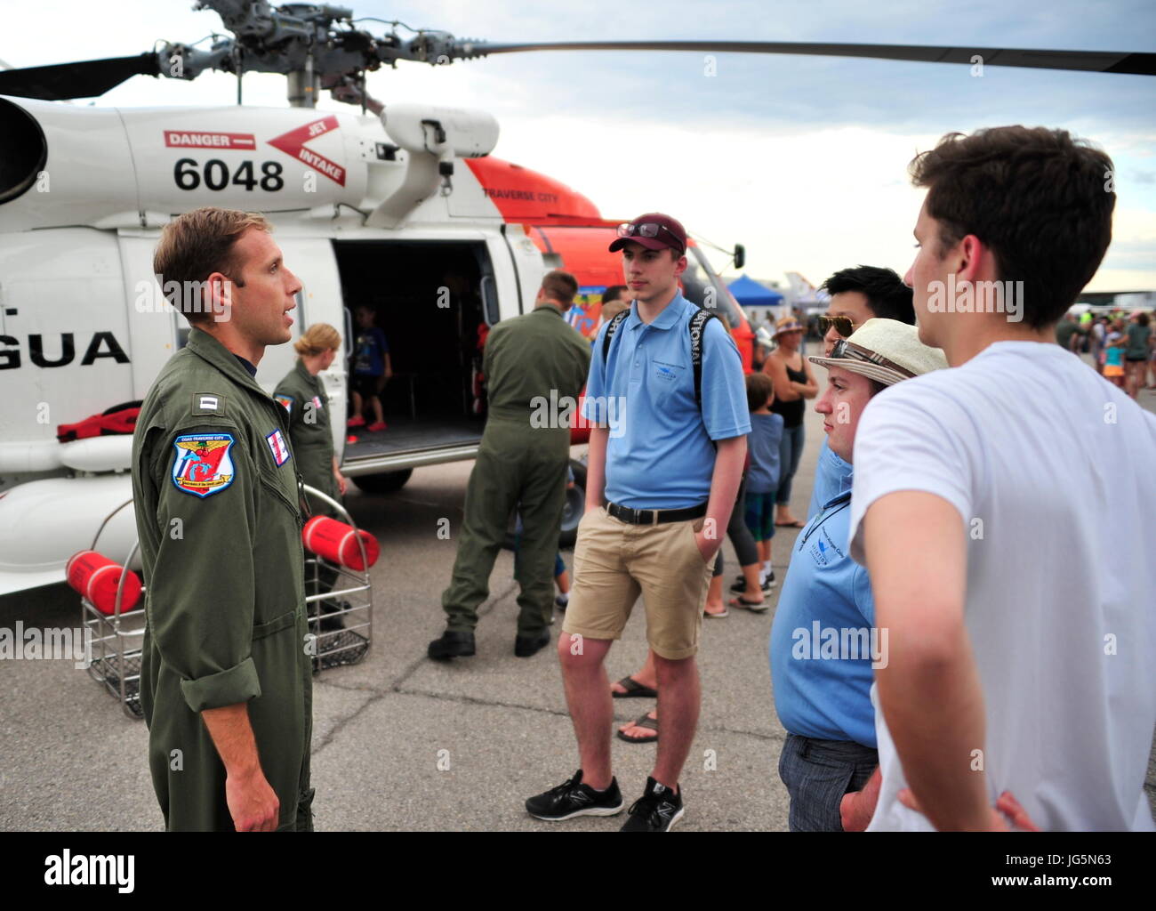 Lt. Ted Borny of Air Station Traverse City discusses the capabilities of the MH-60 helicopter during the “open ramp,” kicking-off the start of the National Cherry Festival in Traverse City, Michigan, June 30, 2017. More than 4,000 people attended the event at the air station to get up close and personal with aircraft and crews that were to participate in the festival Air Show. (U.S. Coast Guard photo by Master Chief Petty Officer Alan Haraf) Stock Photo