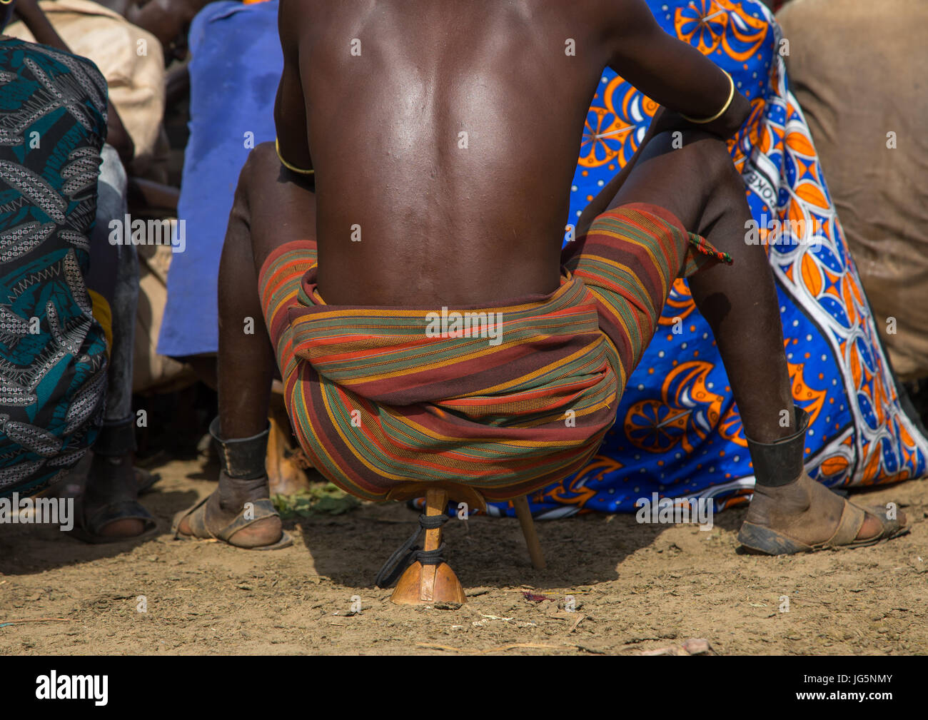 Warrior sit on his wooden seat during the proud ox ceremony in Dassanech tribe, Turkana County, Omorate, Ethiopia Stock Photo