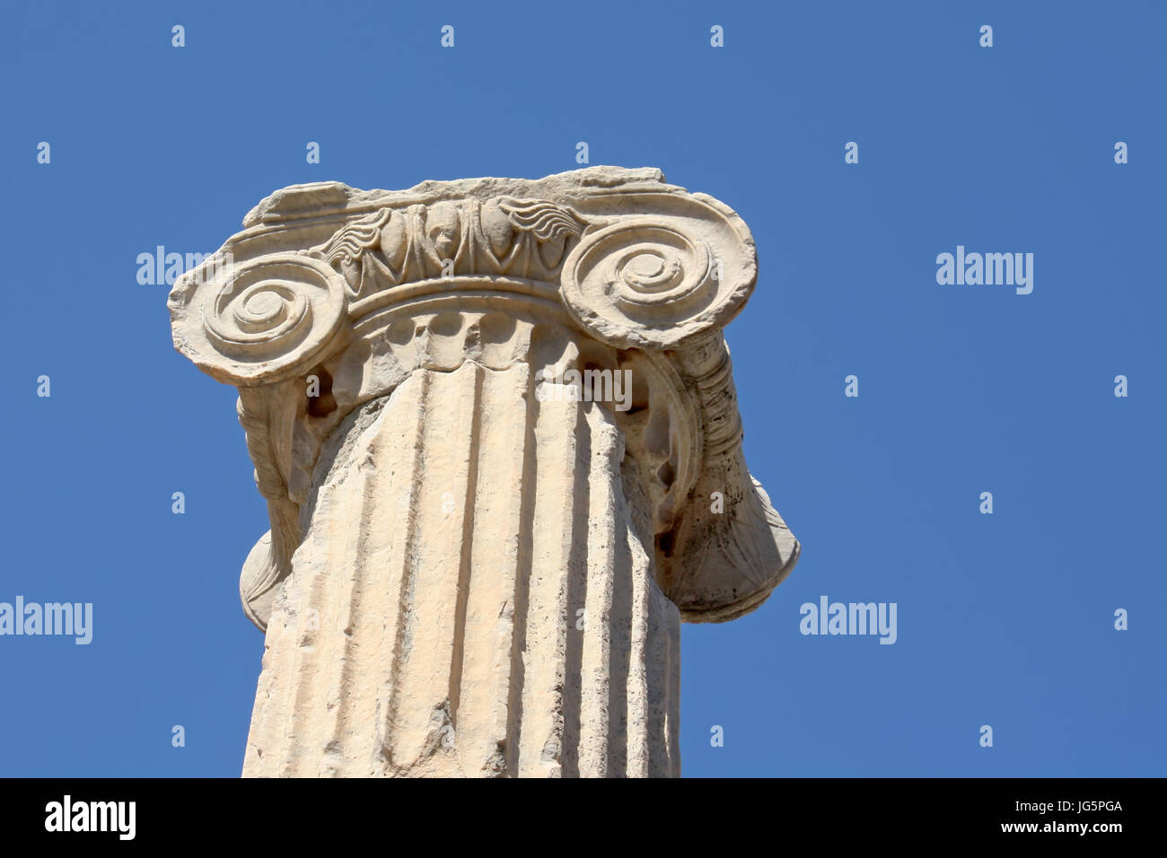 Ionic order column chapiter against blue sky Stock Photo