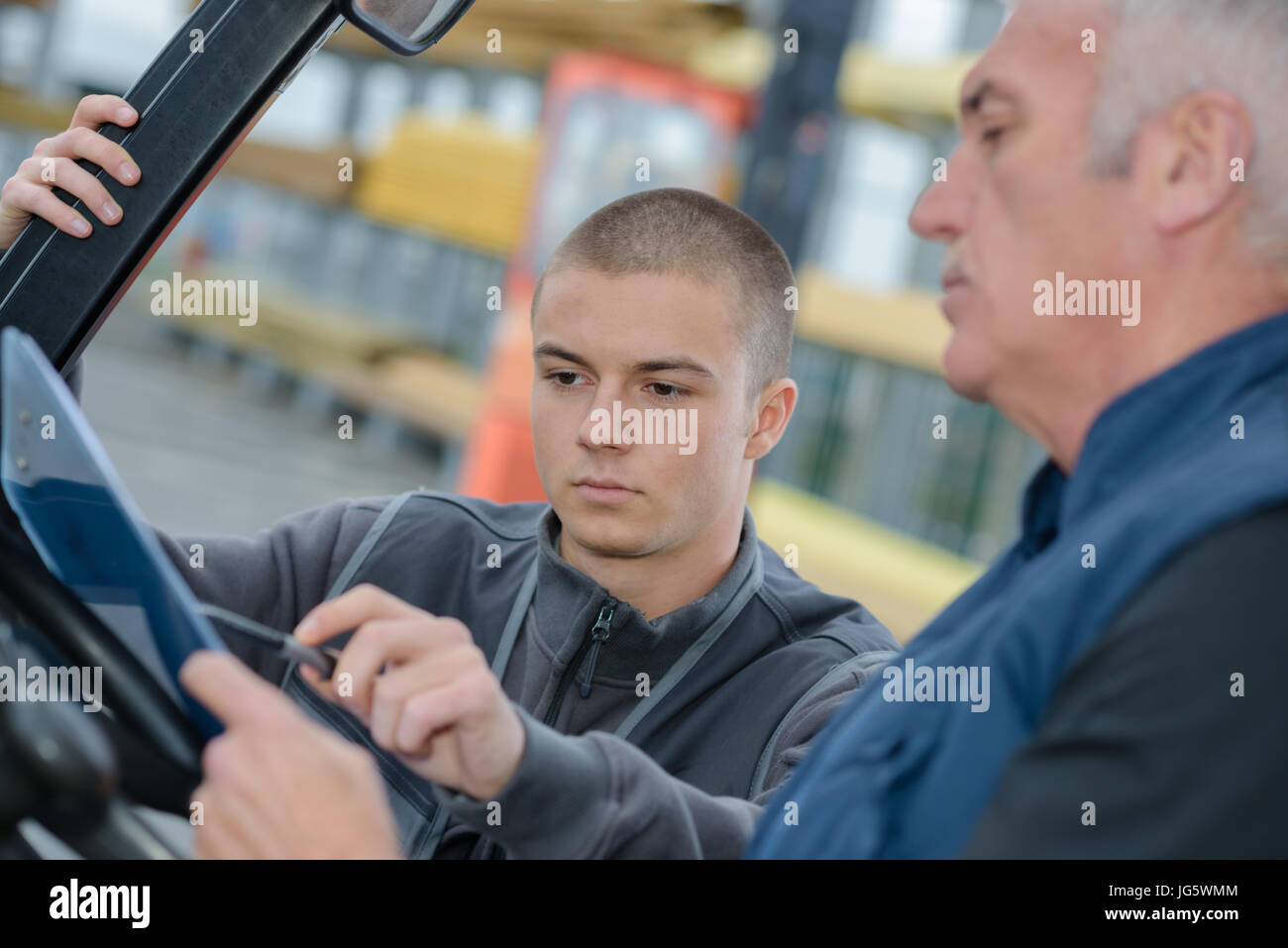 instructor teaching apprentice how to drive a heavy construction