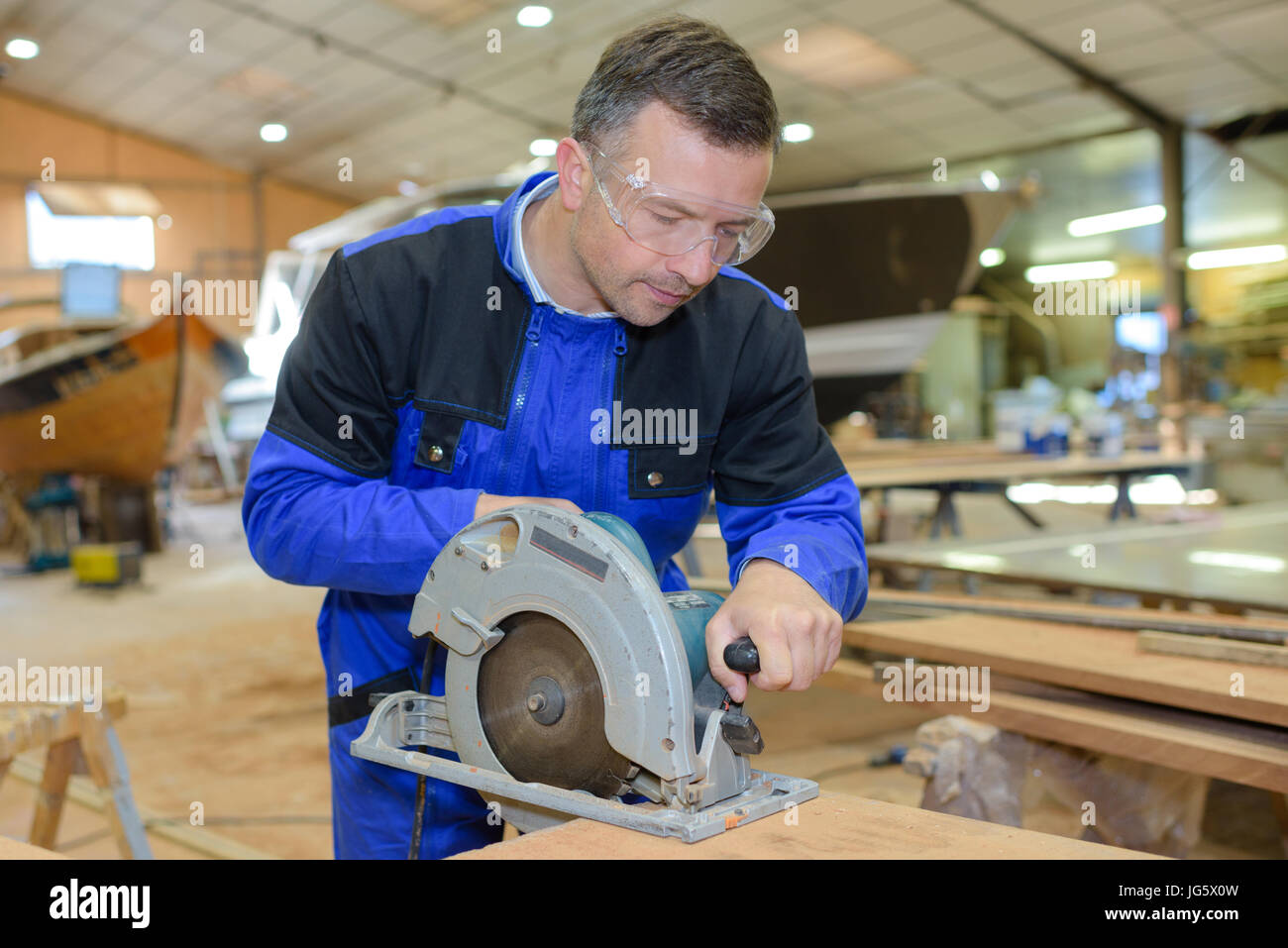 carpenter working man cutting plank by circular saw Stock Photo - Alamy