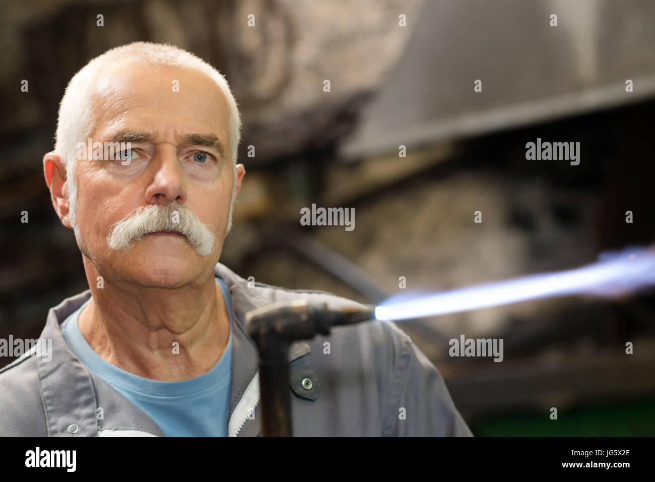 Man Using Blowtorch portrait of a senior man with a blowtorch Stock Photo - Alamy