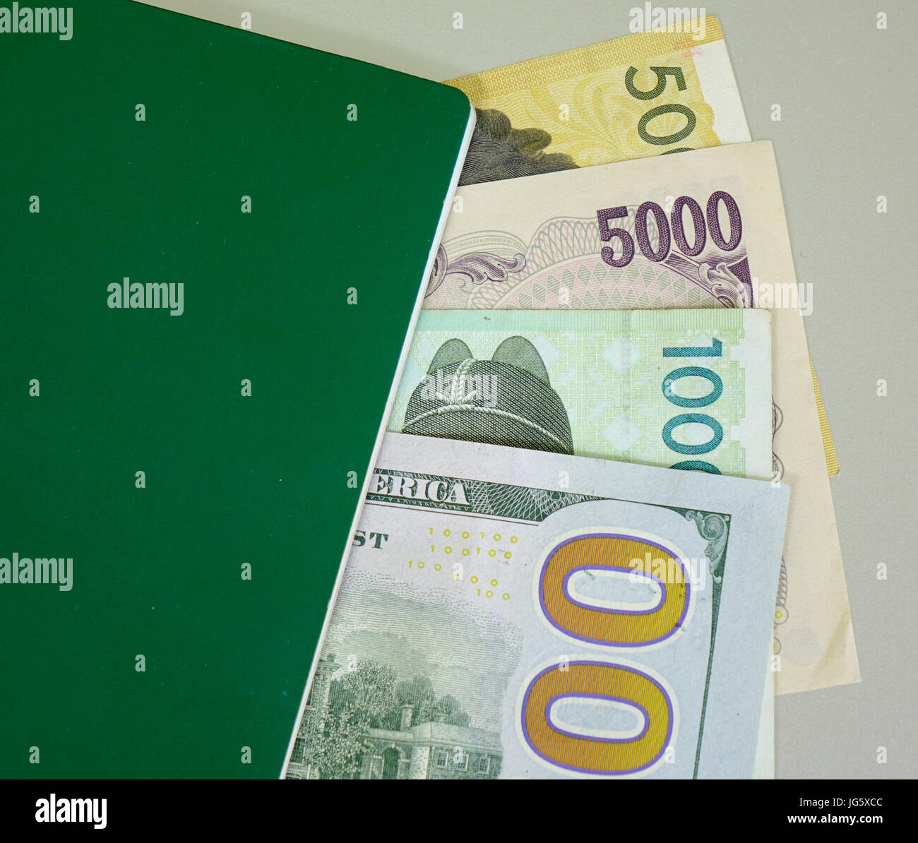Many banknotes (US dollars, Japan yen and Korea won) with green passport -  close up Stock Photo - Alamy