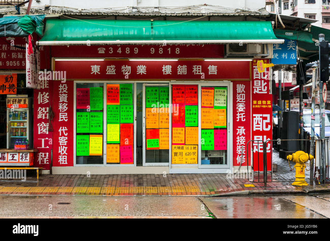 Chinese property agency with rainbow colored adverts posters in Hong Kong China Stock Photo