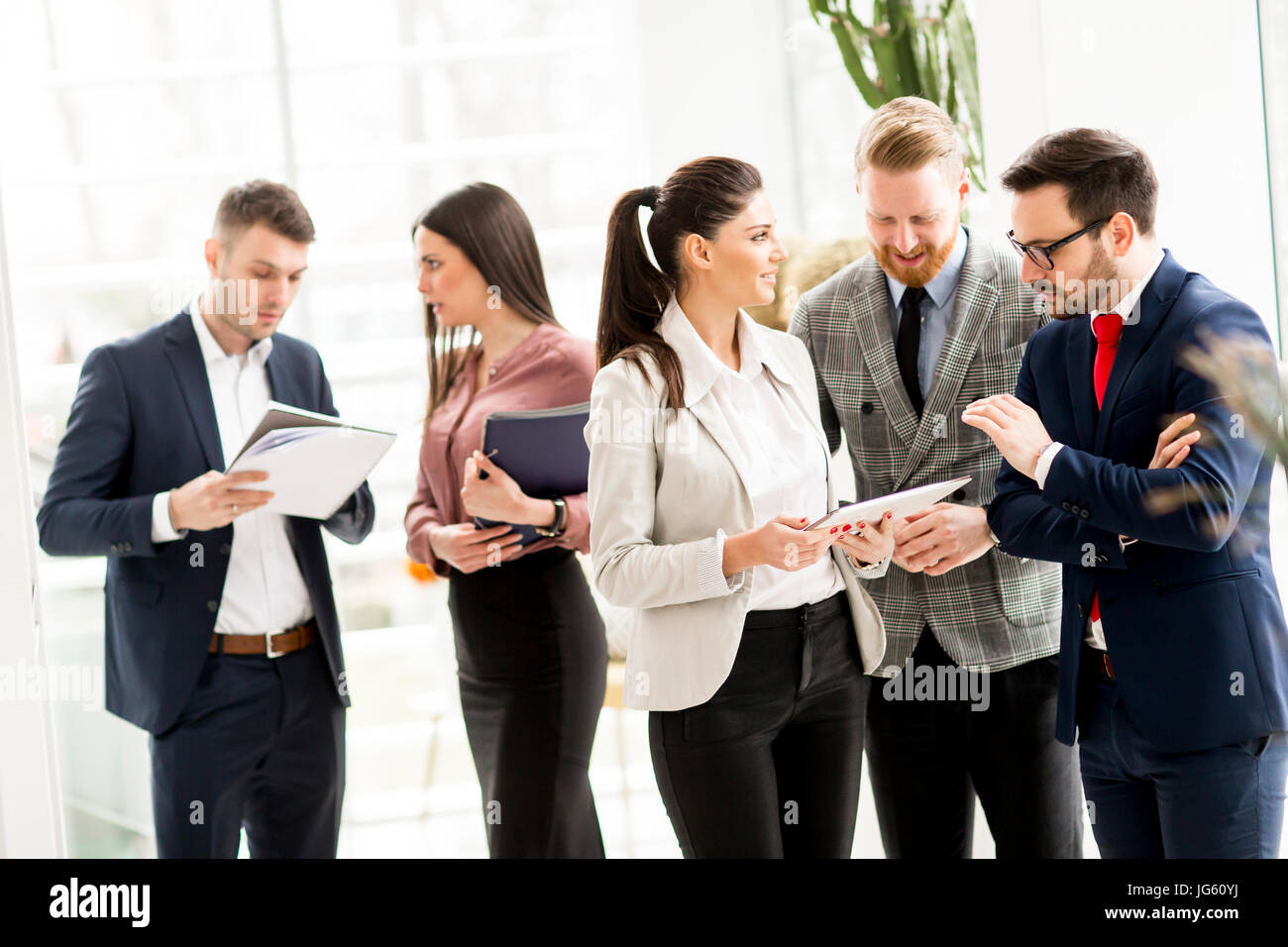 Group of businesspeople standing in the modern office Stock Photo - Alamy