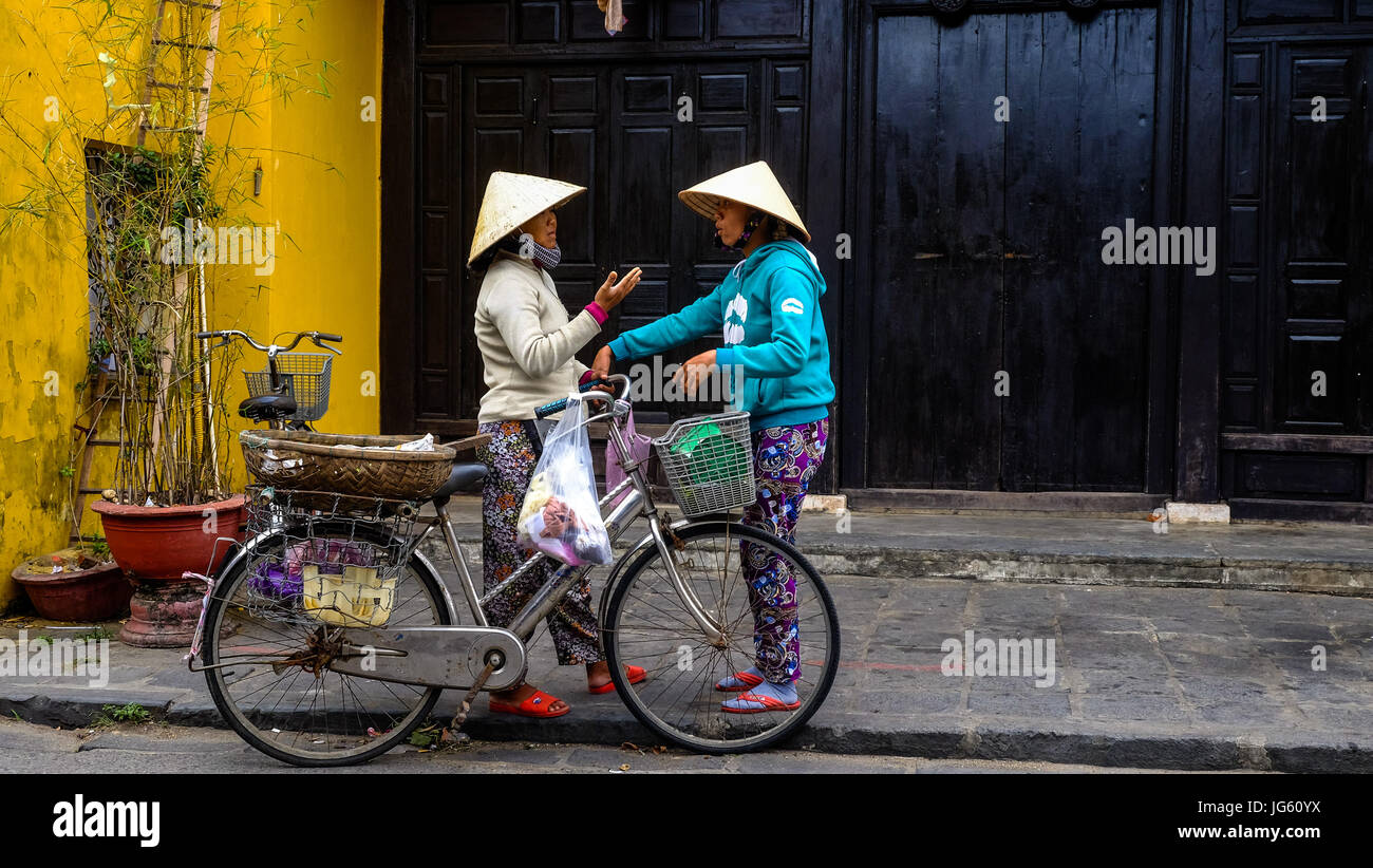 Two Vietnamese woman have an intense discussion in the old town of Hoi An, Vietnam Stock Photo