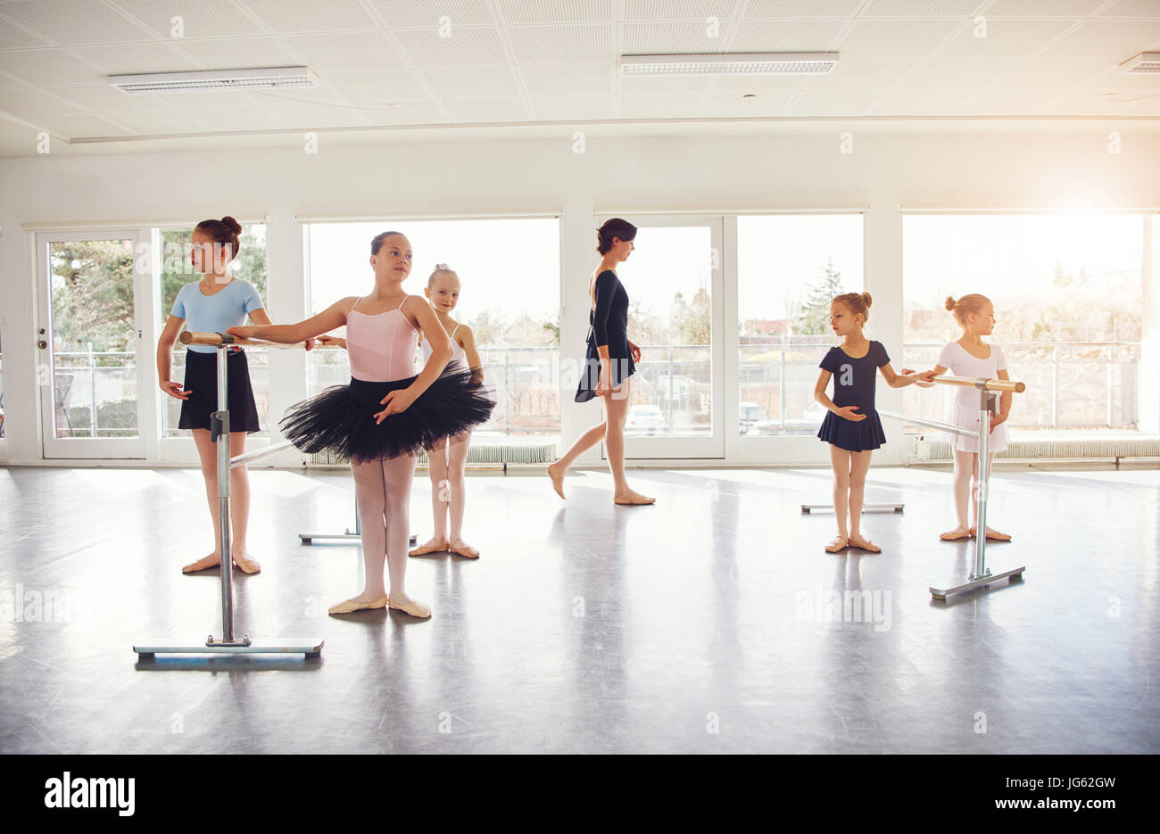 Young girls performing ballet standing and exercising in ballet class. Stock Photo