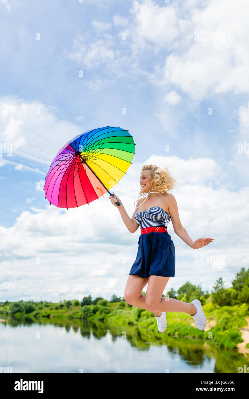 Girl jumping with a colorful umbrella Stock Photo - Alamy