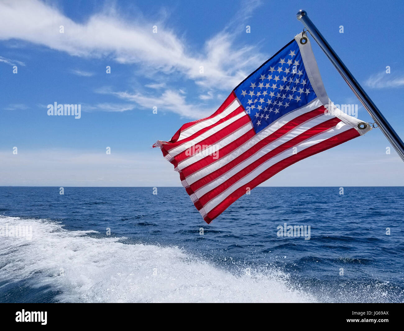 American flag on boat pole with boating wake on Lake Michigan Stock Photo